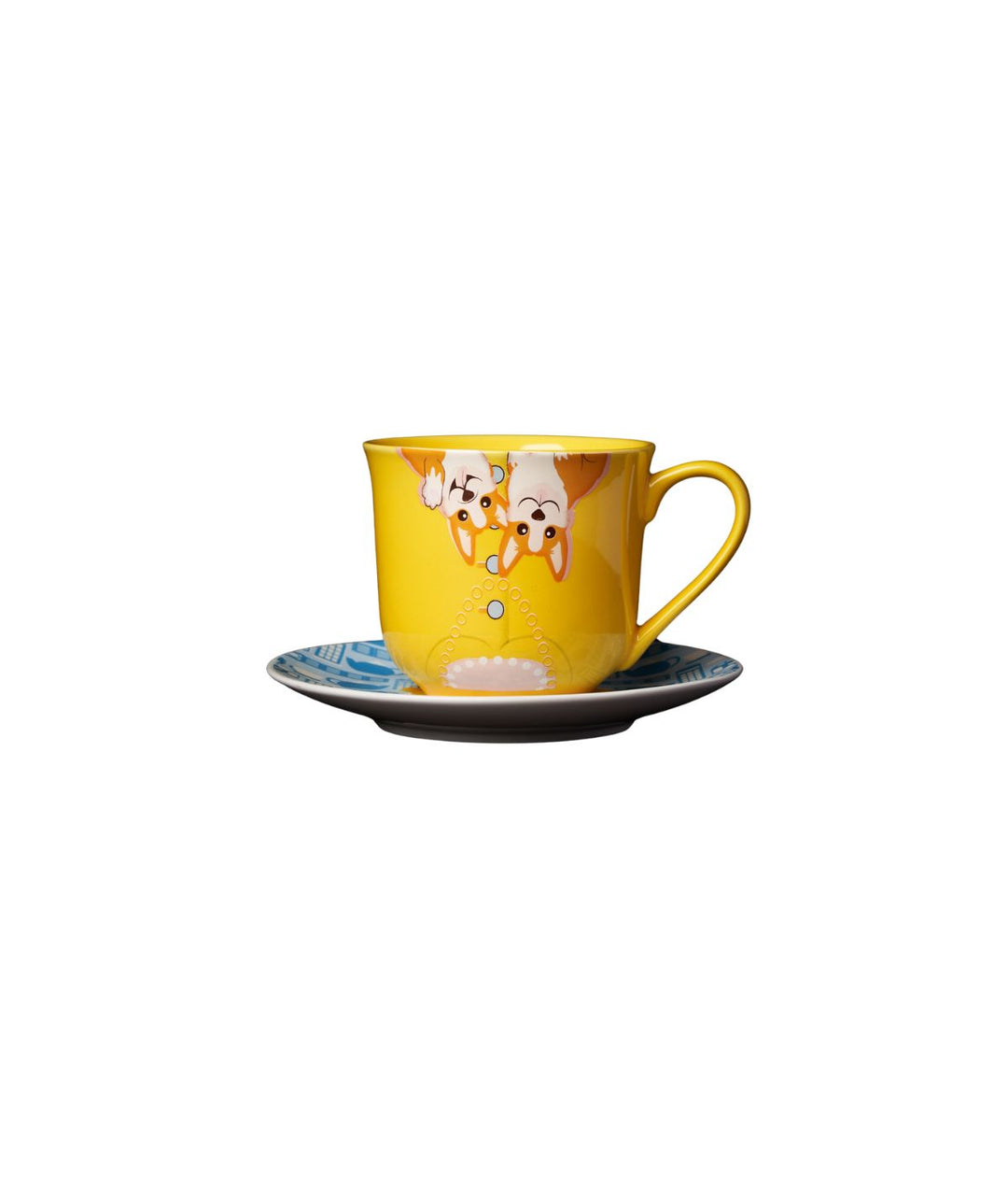 una vista ravvicinata della Tazza con Piattino The Queen, con la tazza gialla decorata con i corgi e il piattino blu con motivi iconici della monarchia britannica.