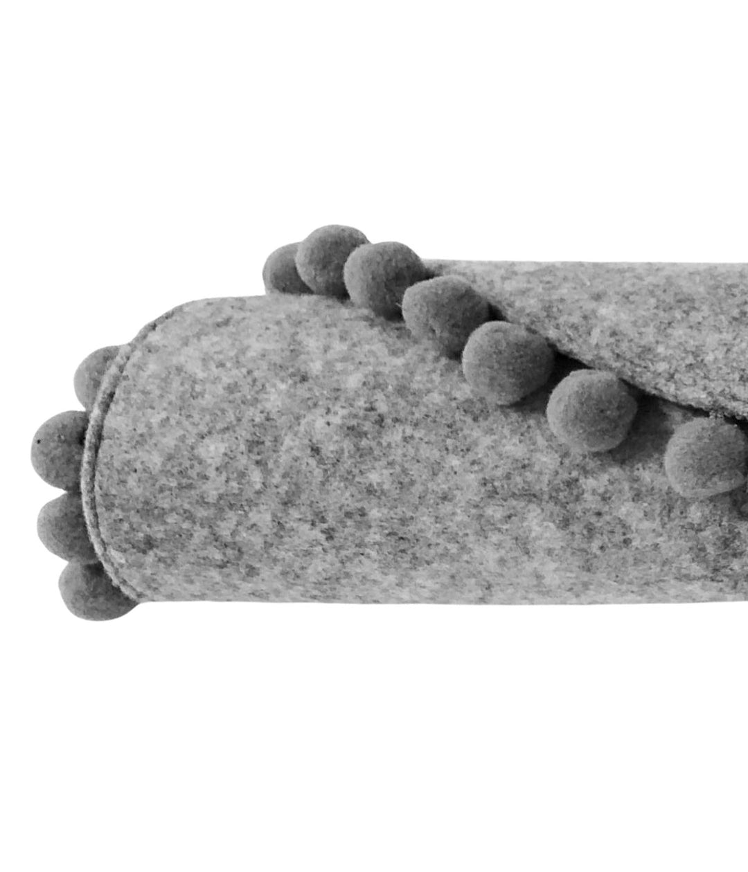 Dettaglio di cuscino per gatti in feltro grigio con pompon decorativi su sfondo bianco. 