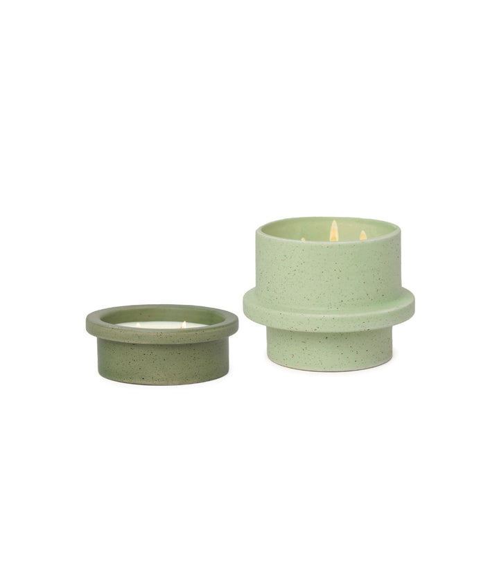 Due candele Folia verdi, una bassa da 141g e una alta da 326g, accese, su sfondo bianco.