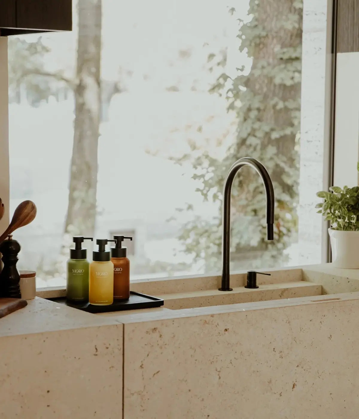Lavabo bagno con i tre dispenser, verde, giallo e marrone su vassoio nero. Sfondo bagno