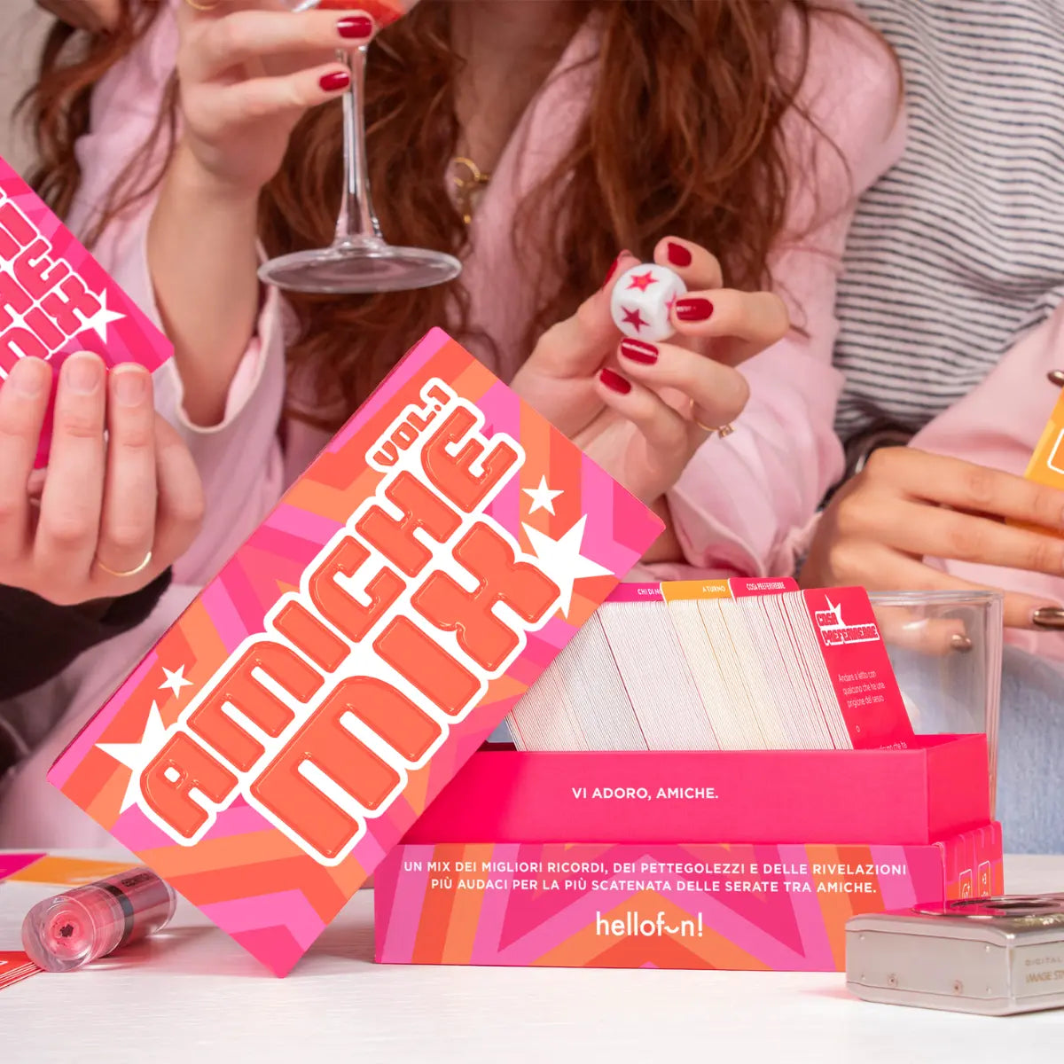 Gioco da tavolo fuxia, amiche mix con carte, dado appoggiato su tavolo bianco. Ragazze che giocano