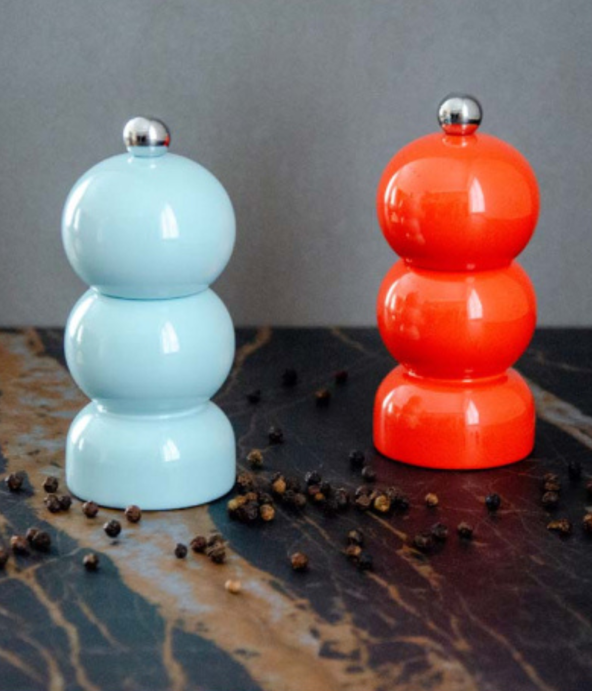Set Macina Sale e Pepe con forma tondeggiante. Celeste e corallo con chicchi di pepe. Sfondo tavolo