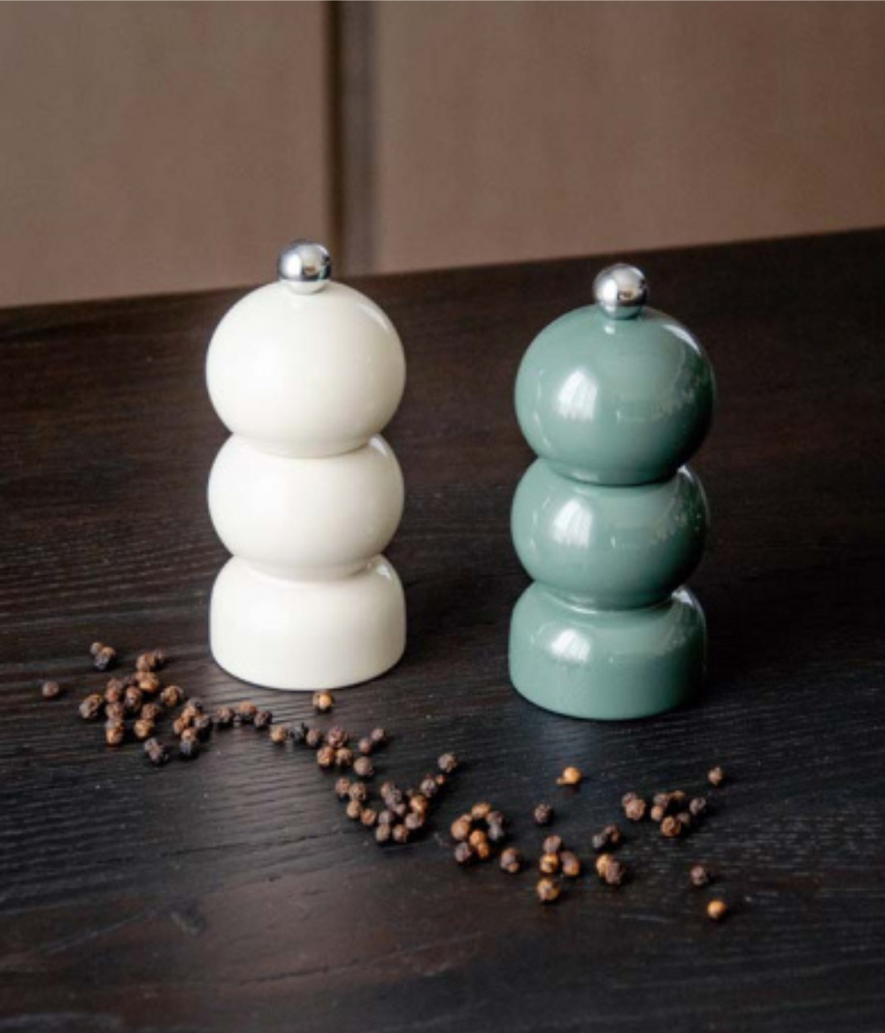 Set Macina Sale e Pepe con forma tondeggiante. Crema e antracite con chicchi di pepe. Sfondo tavolo