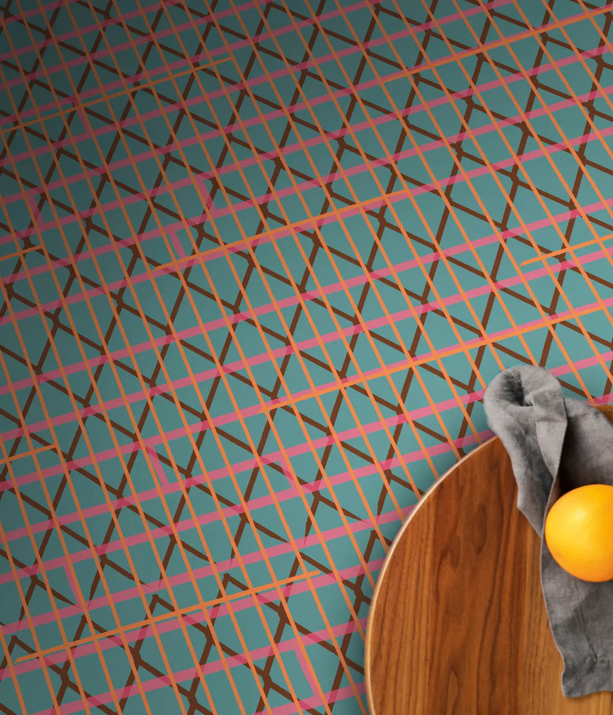 Un tappeto verde, con righe colorate e rombi marroni. Tavolino marrone con mela gialla sopra. 