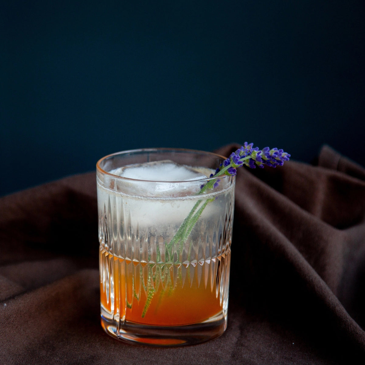 bicchiere da rum su canovaccio marrone con cubo di ghiaccio