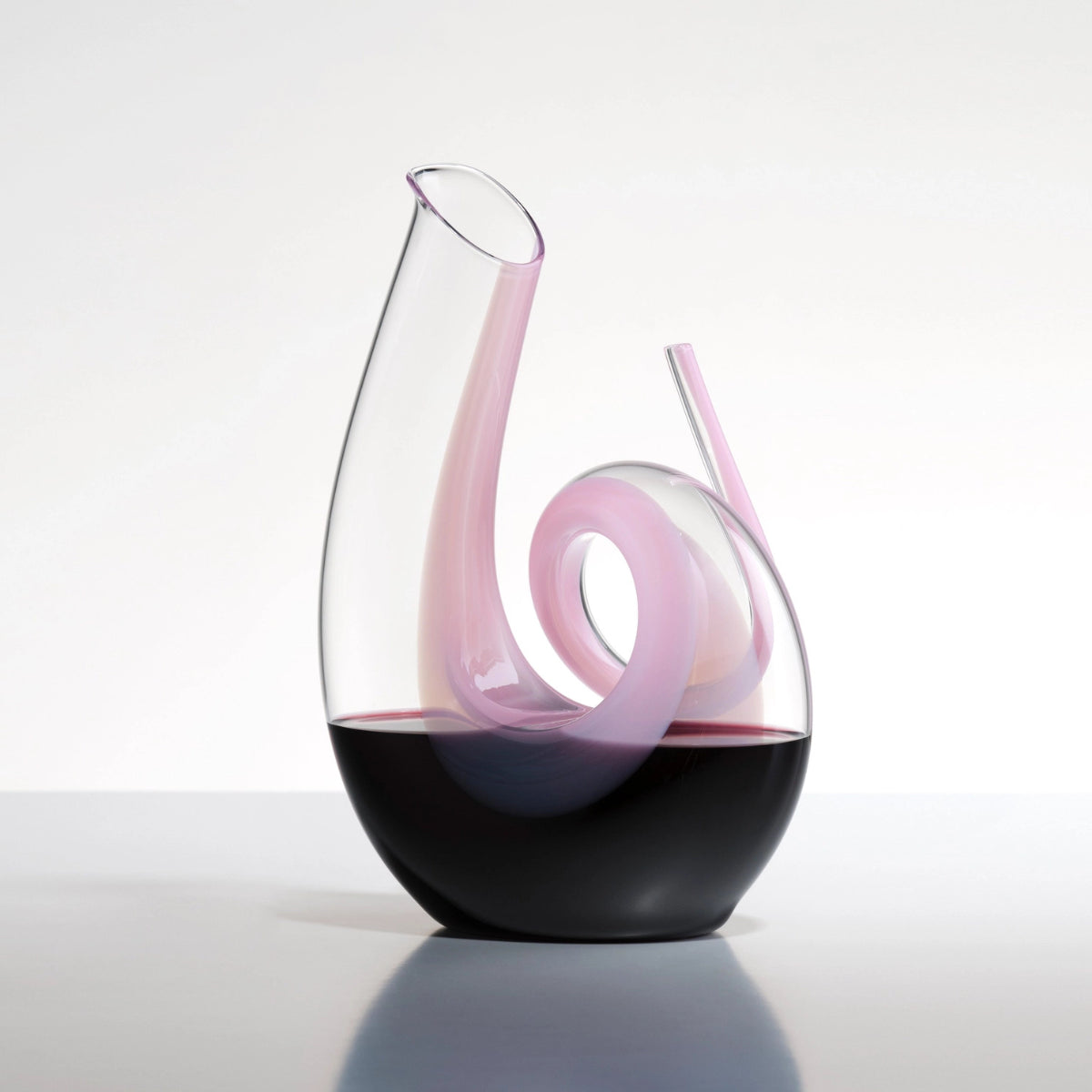 decanter rosa riedel riempito di vino, appoggiato su un piano