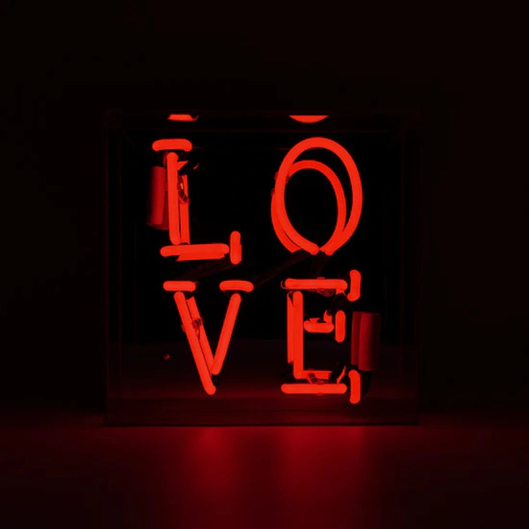 insegna neon love rossa, ambientata in uno spazio luminoso rosso  