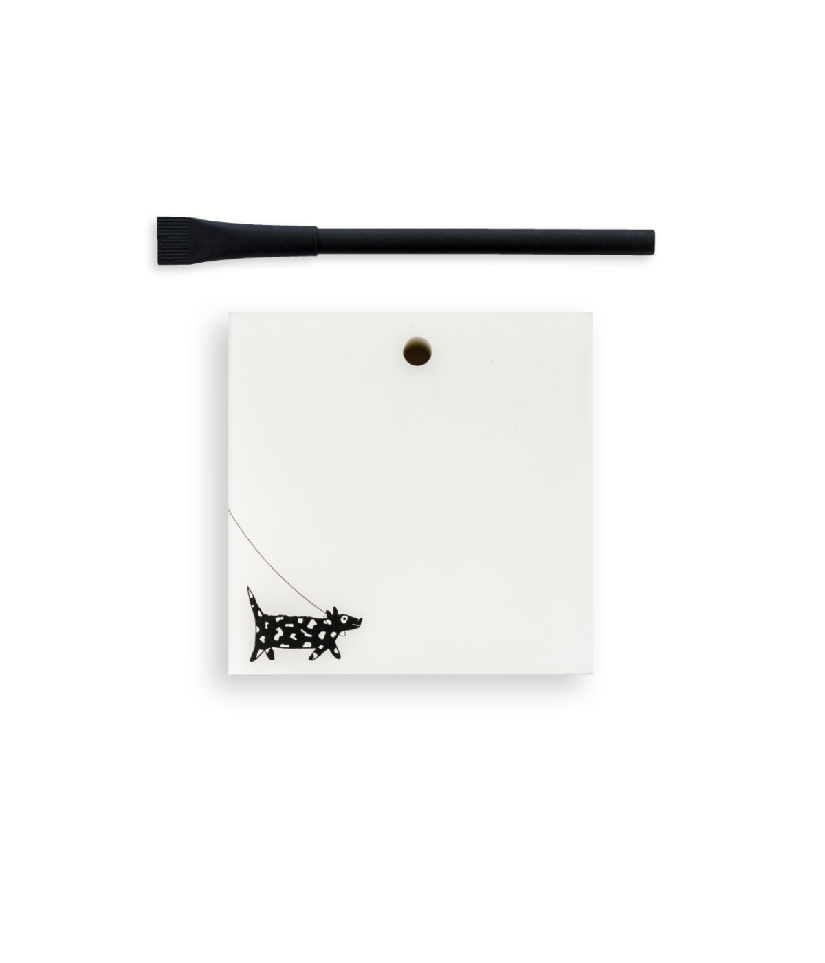 Blocknote bianco con disegno nero cane, buco porta penna e penna nera di design. Sfondo bianco.