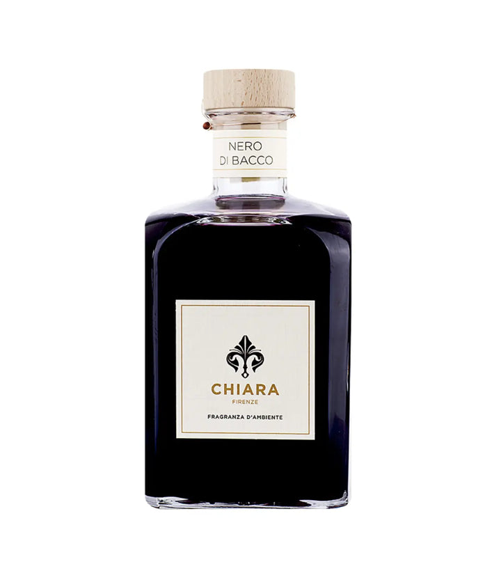 Una bottiglia in vetro trasparente con fragranza viola. Etichetta Chiara Firenze, Sfondo bianco