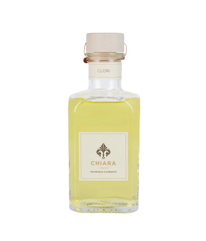 Una bottiglia vetro trasparente con fragranza gialla. Etichetta Chiara Firenze Clori. Sfondo bianco