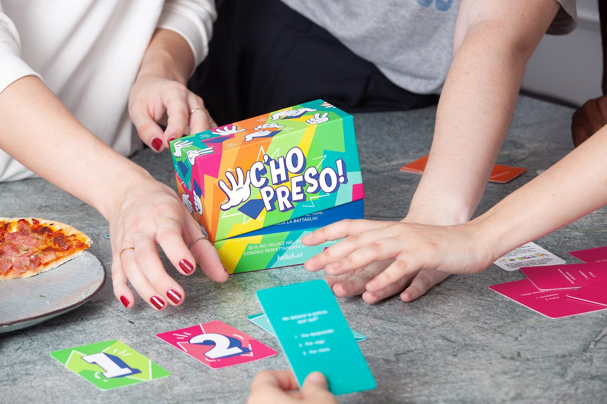 Persone che giocano a carte con il gioco di Hellofun su un tavolo