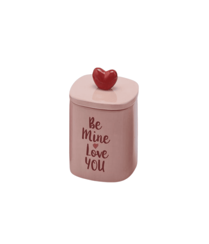Candela con scritta Be Mine Love You rossa e contenitore in ceramica bianca. Immagine su sfondo bianco. 