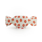 Lampada da tavolo a forma di caramella con base bianca e fantasia con baci rossi. Sfondo bianco 