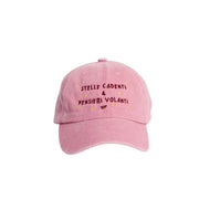 Cappellino rosa con scritta ricamata bordeaux "Stelle cadenti e pensieri volanti". Stelline ricamante gialle intorno alla scritta. Sfondo bianco 