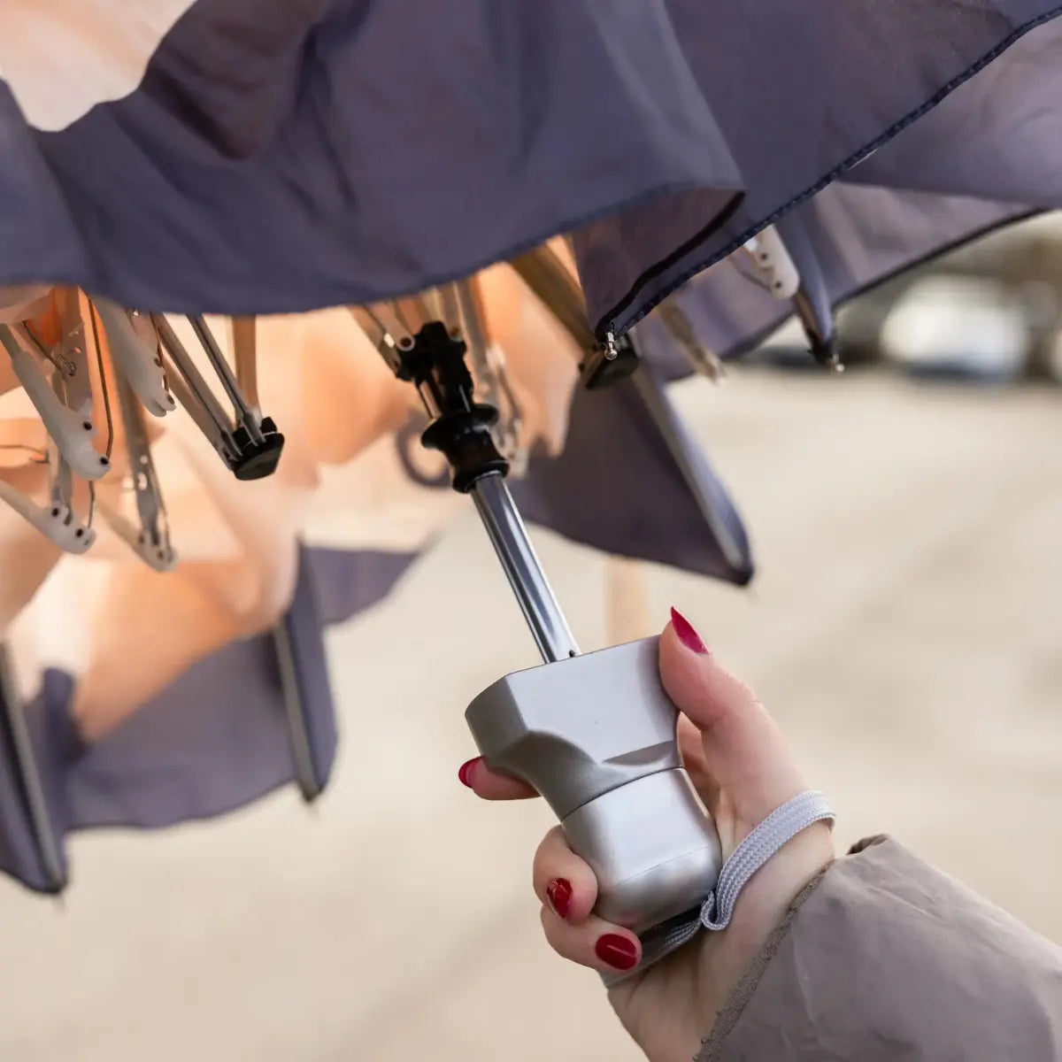 Mano femminile che tiene in mano l'ombrello e mostra la chiusura dell'ombrello tascabile doppio All you need is love