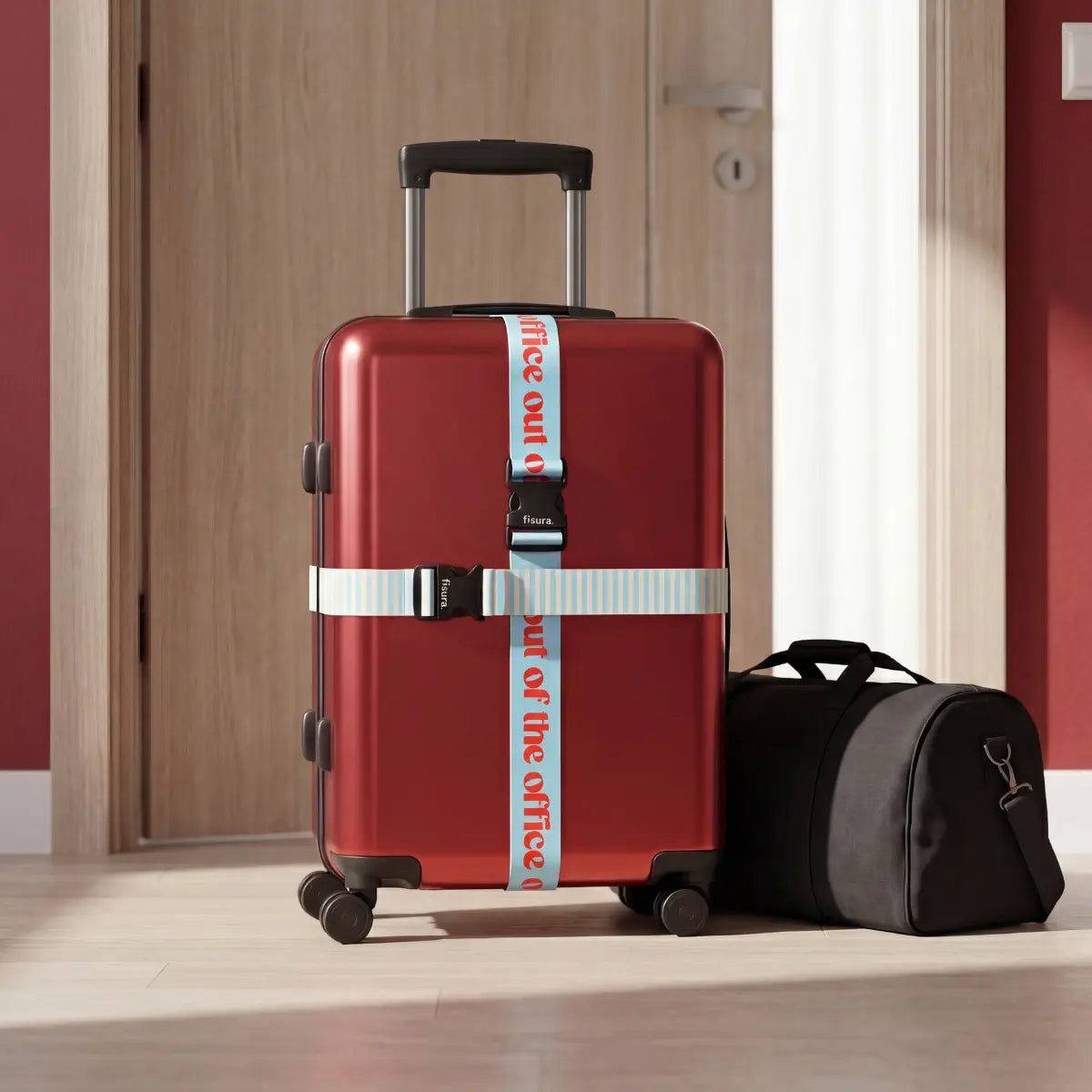 Valigia con set di 2 cinghie per valigia una con scritta "Out of the office" rossa su sfondo azzurro e una righe bianche e azzurre. 