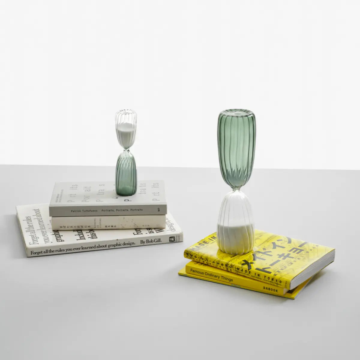 Due clessidre della collezione Times di Ichendorf posizionate su dei libri su un tavolo