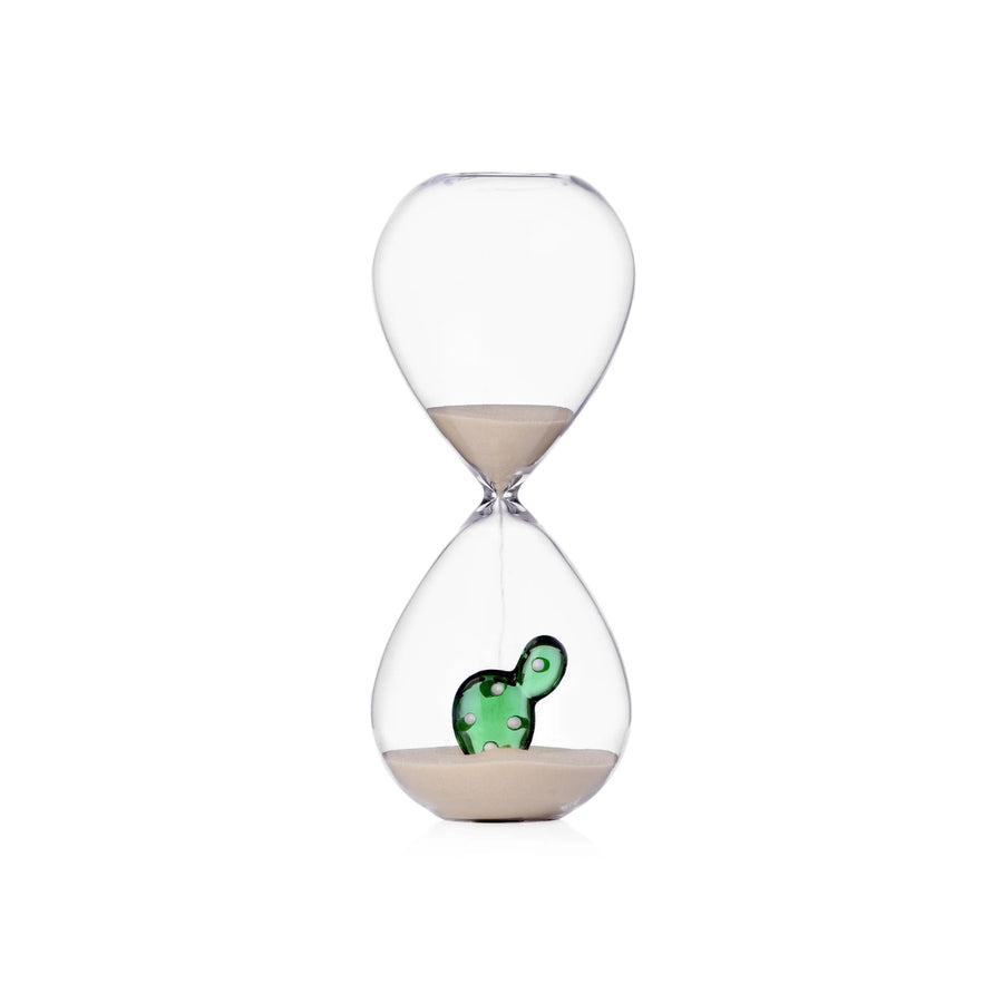 Clessidra in vetro con cactus sospeso verde, puntini bianchi. Sabbia che scorre. Sfondo bianco