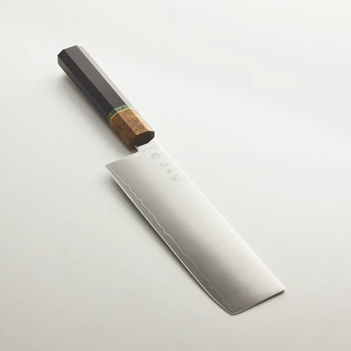 Coltello con lama rettangolare e scritta e lavorazione damascata, manico nero con dettaglio verde e color legno.