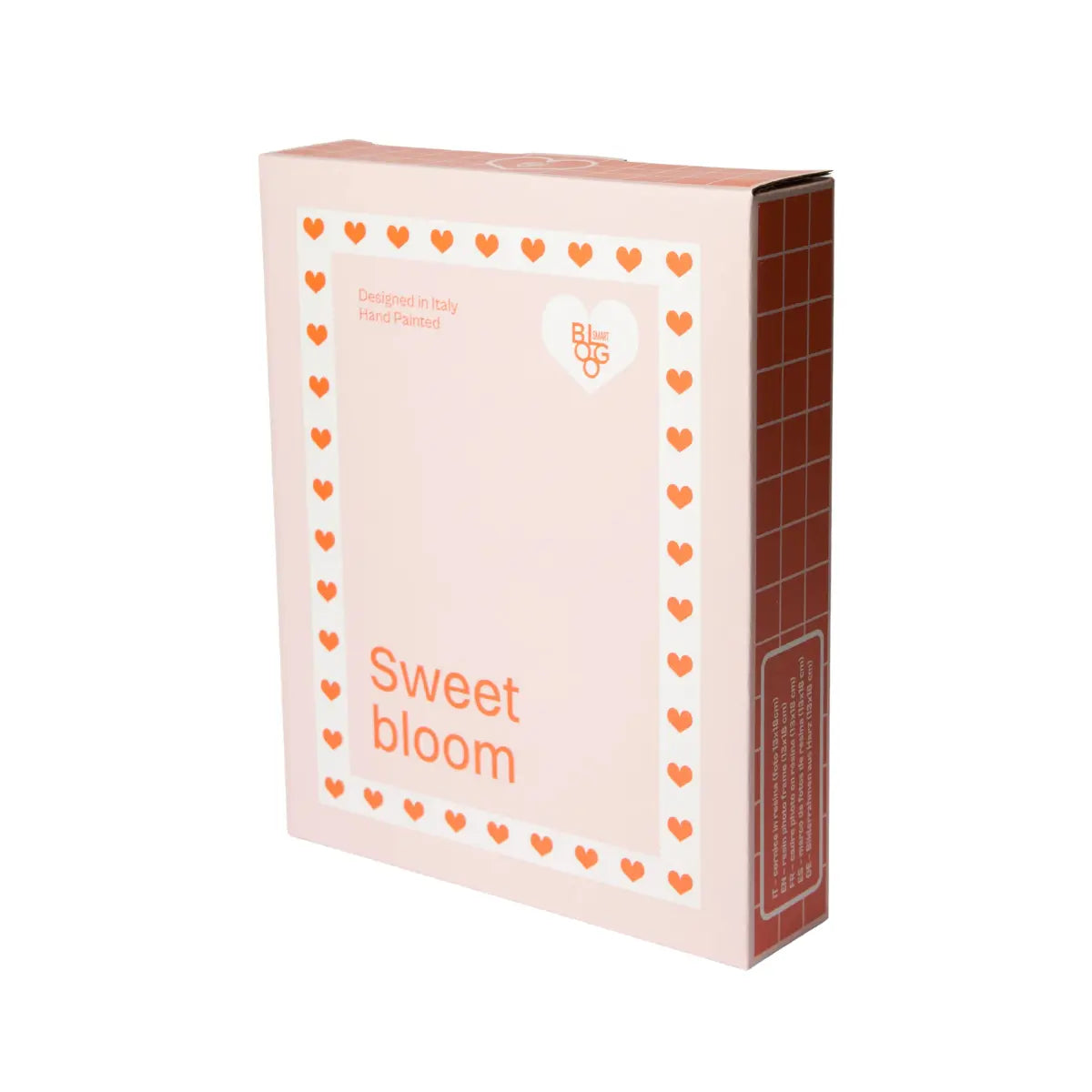 Scatola rosa con dettagli a forma di cuore e scritte rosse. Sfondo bianco