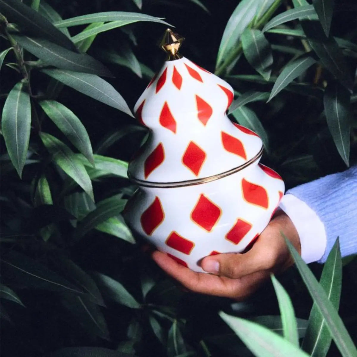 Contenitore per dolci Delight di Alessi ispirato alla forma dell'abete tenuto in mano