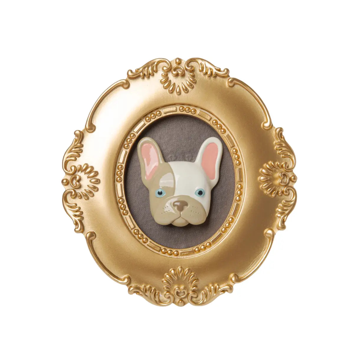 Cornice oro di forma ovale con il volto di un bulldog in rilievo con gli occhi azzurri e a macchie bianche e grigie su sfondo grigio. L'immagine è su sfondo bianco.