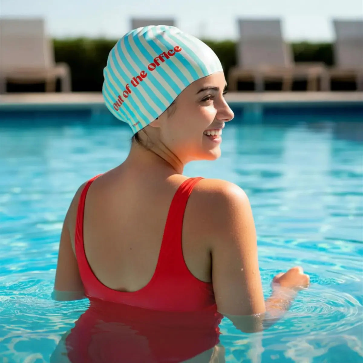Ragazza che indossa la cuffia da piscina a righe in silicone con scritta rossa "Out of the office"