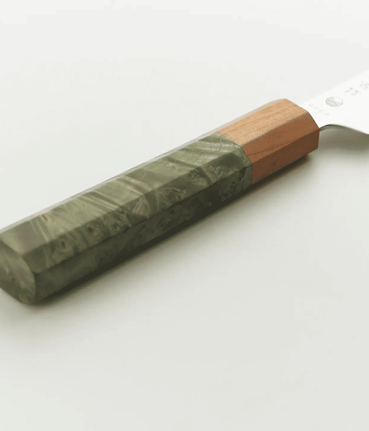 Dettaglio manico coltello verde e legno. Immagine su sfondo bianco.