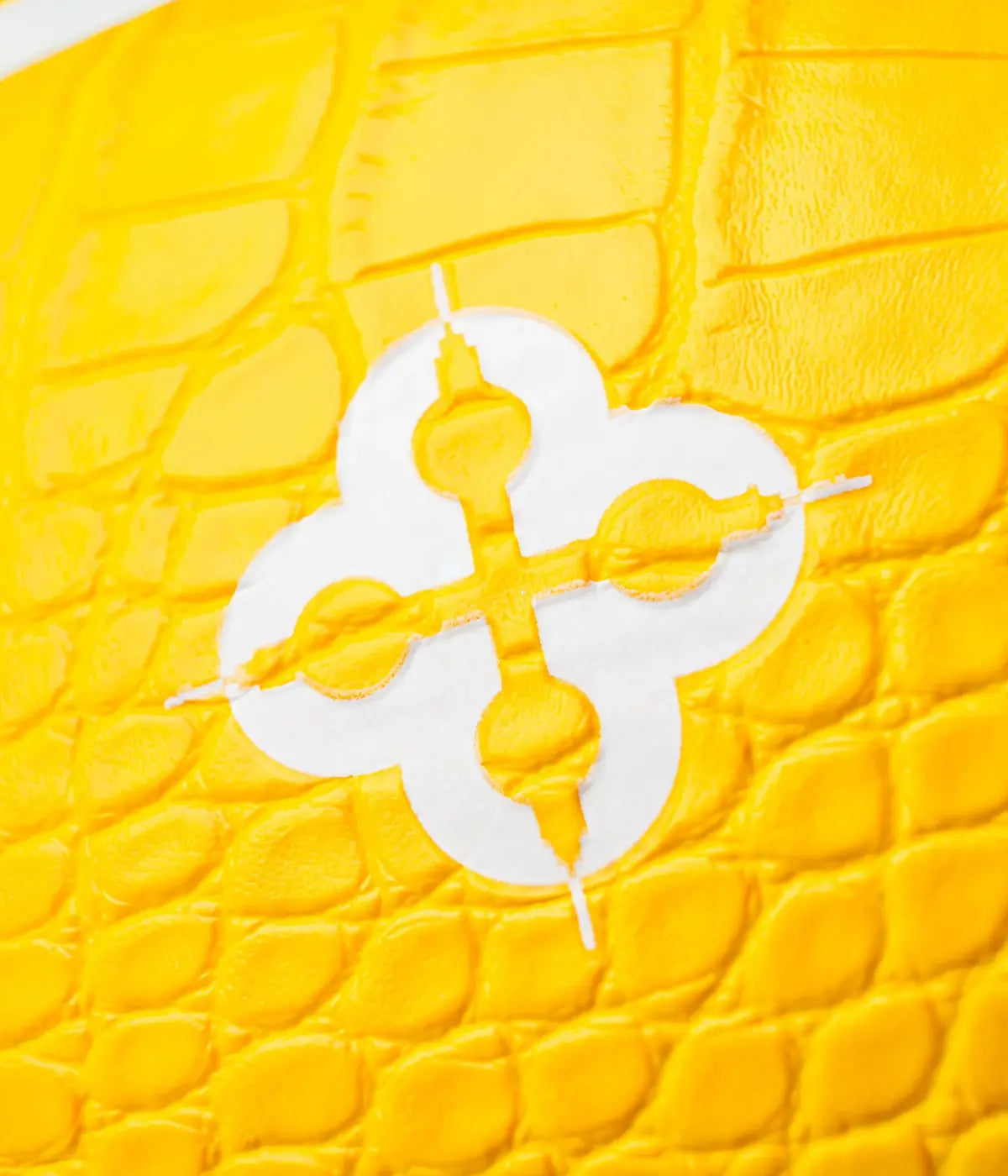 Dettaglio marchio bianco e giallo su palla da basket gialla texture coccodrillo.