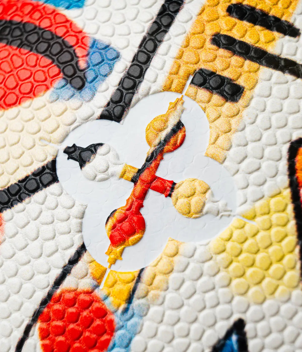 Dettaglio marchio bianco e colorato su alla da basket con disegni street art di vari colori.