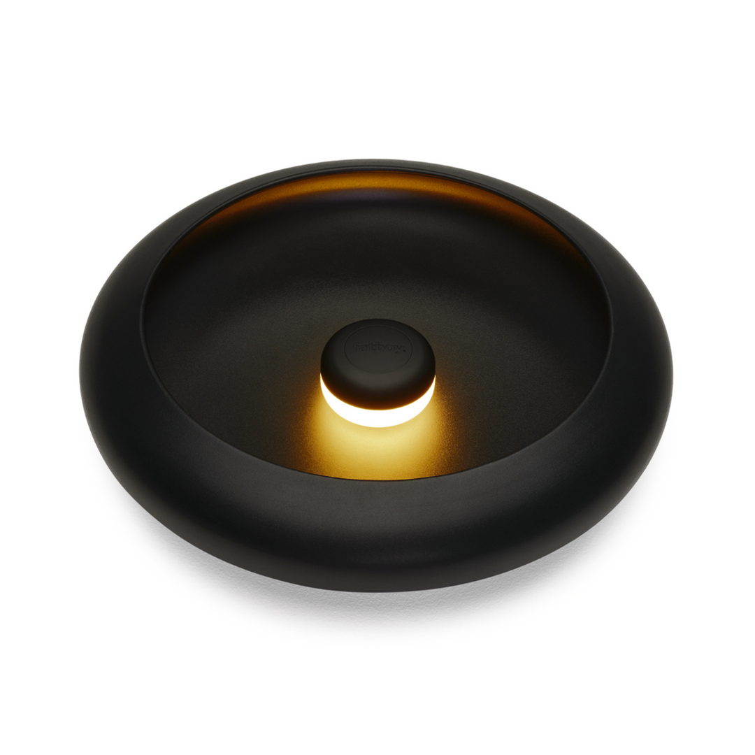 Lampada da tavolo/ svuotatsche rotonda nero con luce accesa al centro. Sfondo bianco
