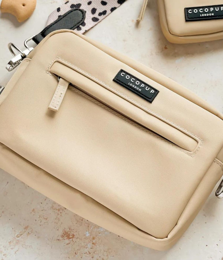 Borsa da passeggio crema su sfondo chiaro, con tracolla abbinata.