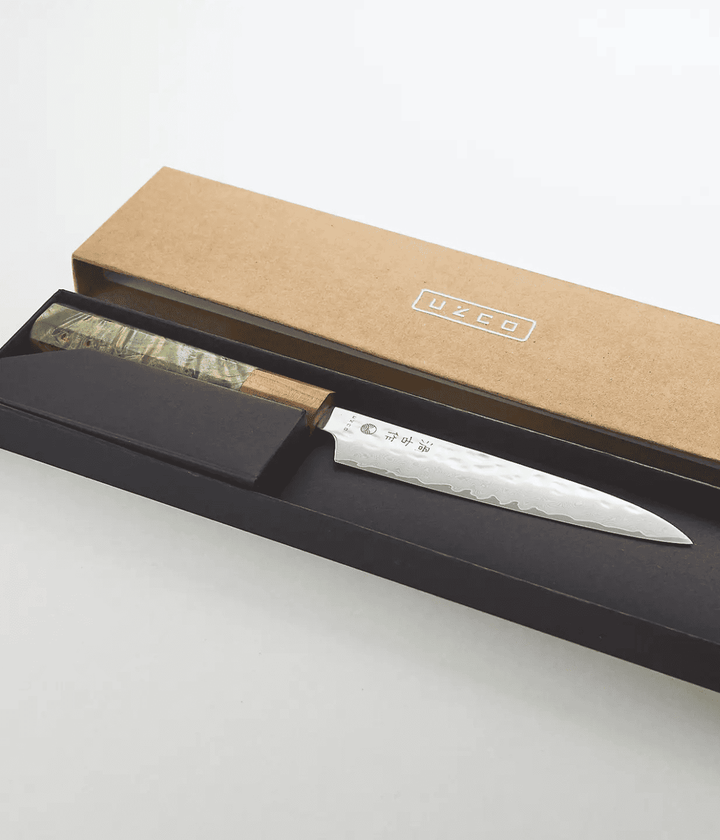 Scatola Coltello, interno nero che contiene il coltello con manico verde e legno e lama in acciaio.