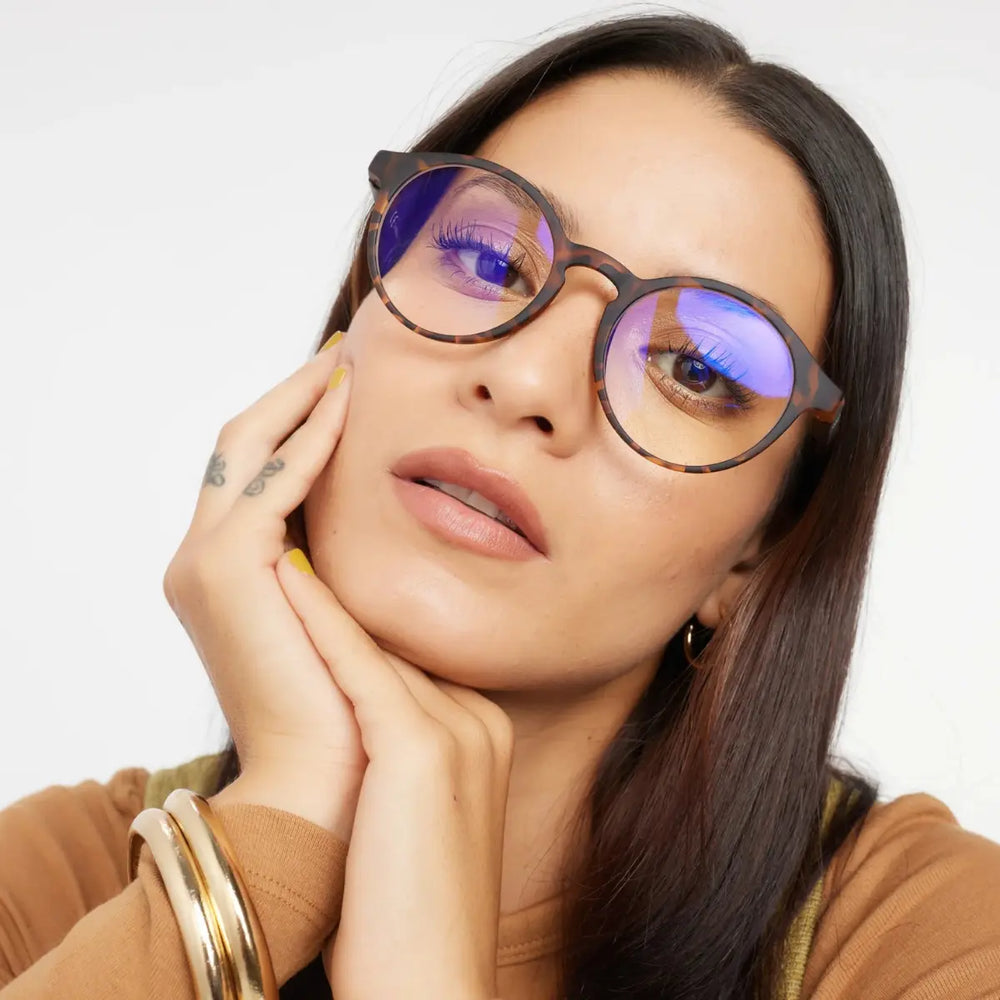 Occhiale marrone design tartaruga finitura opaca, con protezione luci blu indossato da donna mora.
