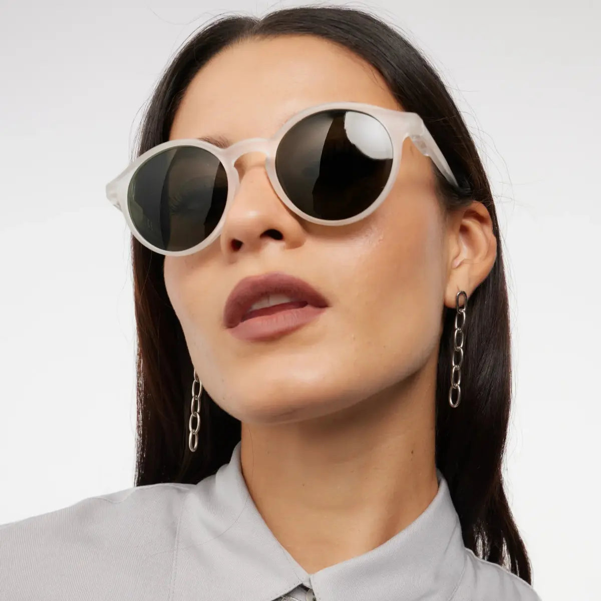 Occhiale da sole bianco finitura opaca, indossato da donna mora.
