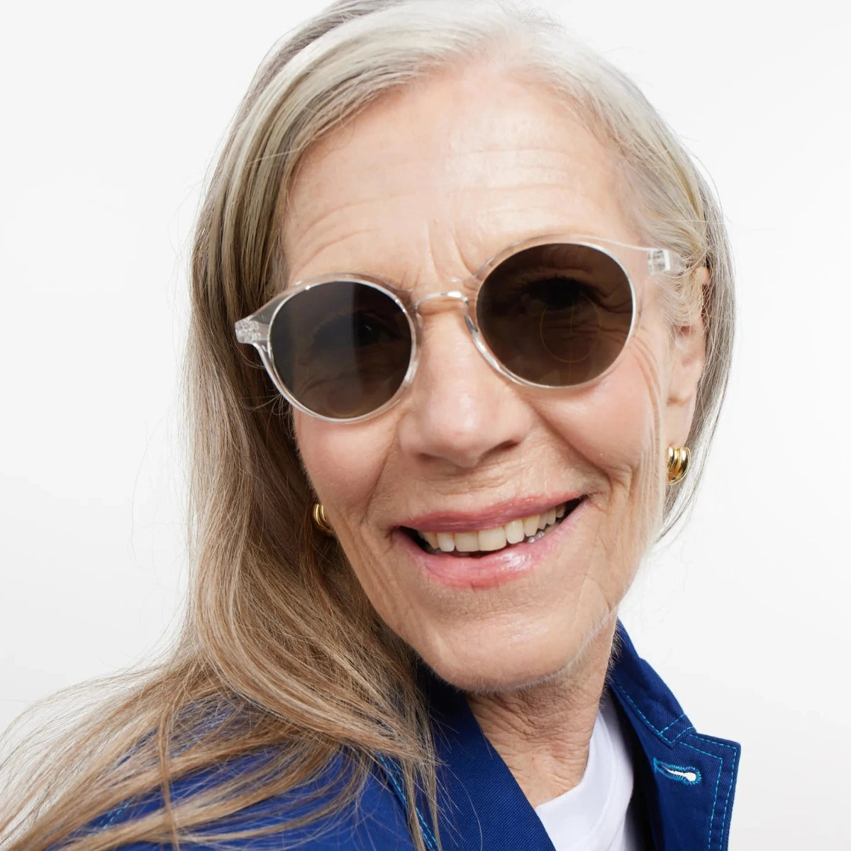 Occhiale da sole finitura trasparente lucida, lenti scure indossato da donna bionda