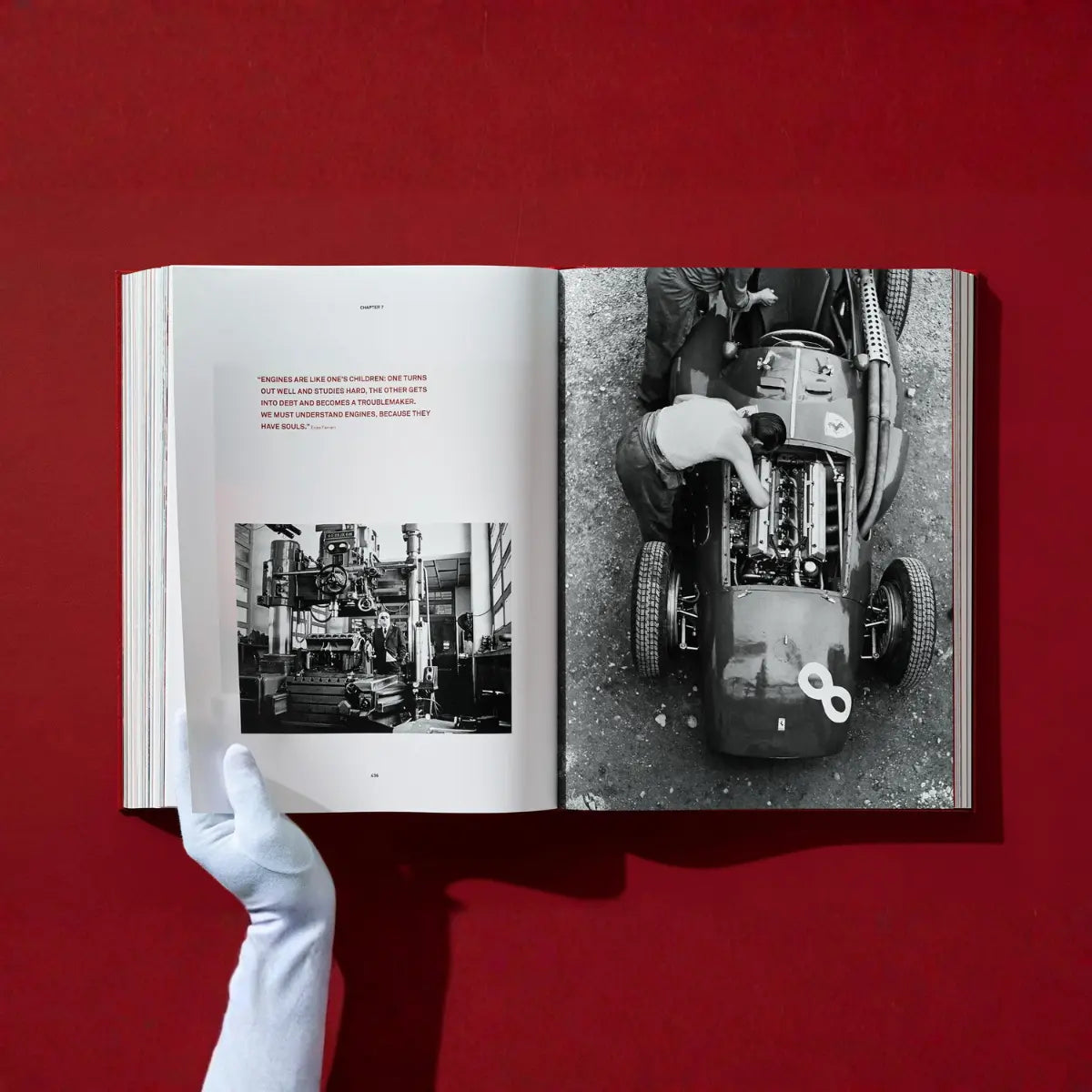 Mano che sfoglia le pagine del libro Ferrari di Taschen. Numerose foto e brevi testi