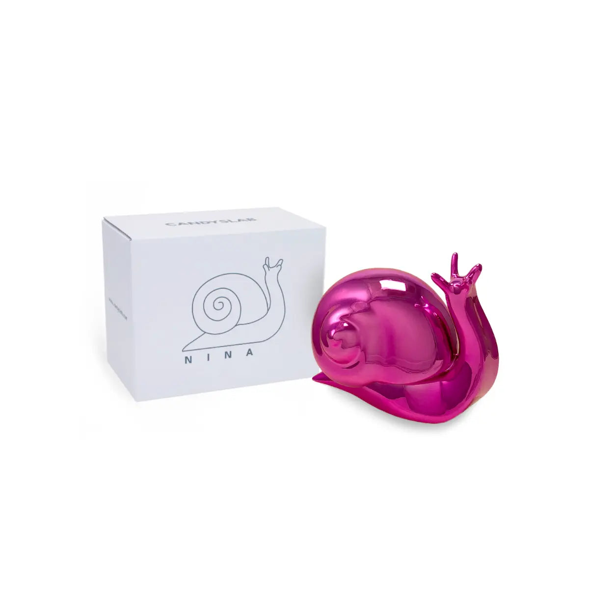 Confezione bianca con scritte e disegni in nero. Accanto posizionato il fermalibri Nina a forma di lumaca nella versione cromata fucsia. Sfondo bianco 