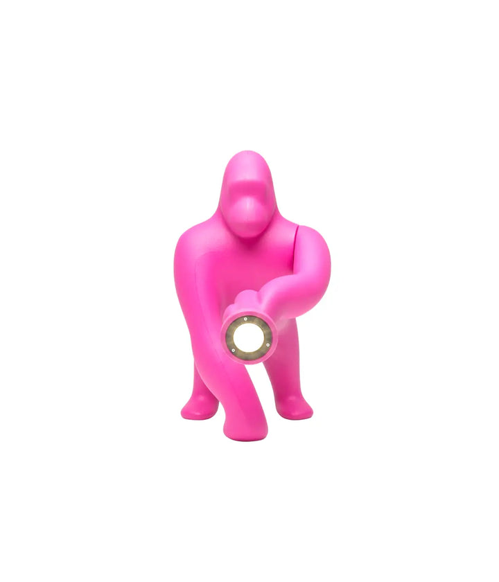 Lampada a forma di King Kong fuxia. Un braccio regolabile con in fondo la luce. Sfondo bianco