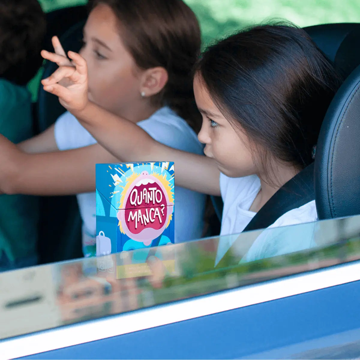 Due bambine in macchina che giocano con Quanto Manca
