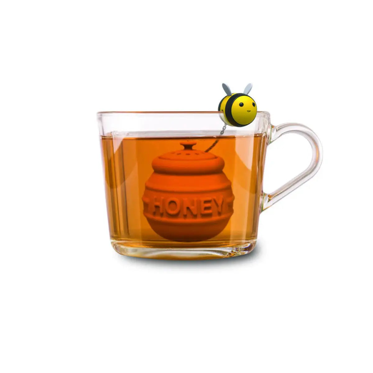 Infusore per te a forma di alveare immerso nel te e ape in silicone agganciata alla tazza in vetro. Sfondo bianco 