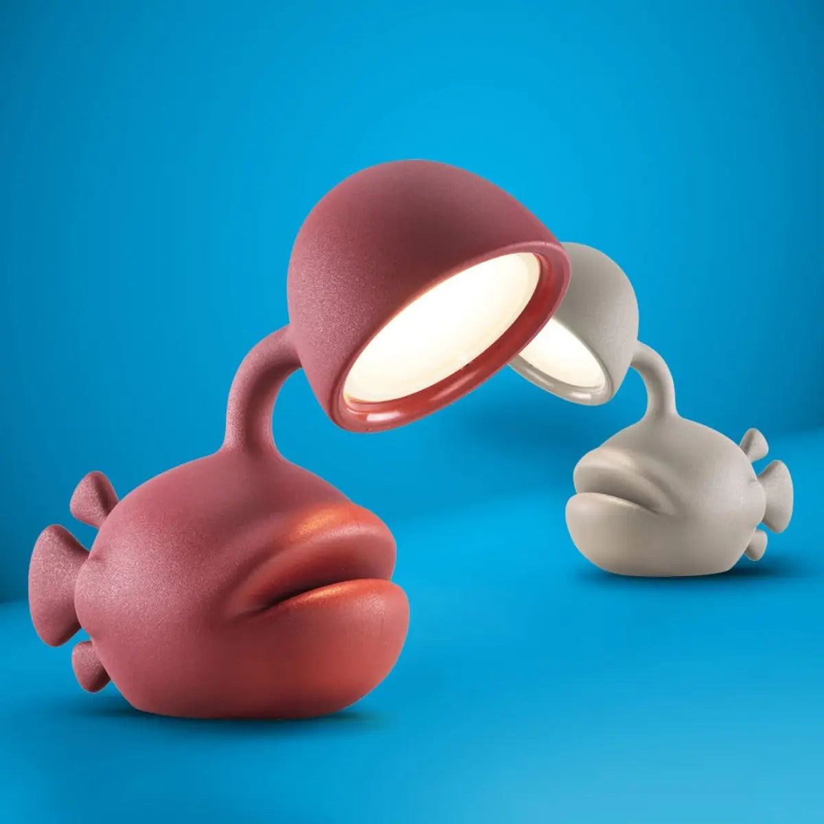 Due lampade a forma di pesce con lanterna, una rossa e una grigia su sfondo azzurro