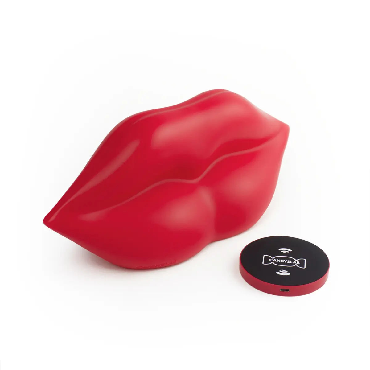 Lampada da tavolo rossa a forma di labbra. Appoggiato accanto alla lampada c'è la base di ricarica wireless. Sfondo bianco