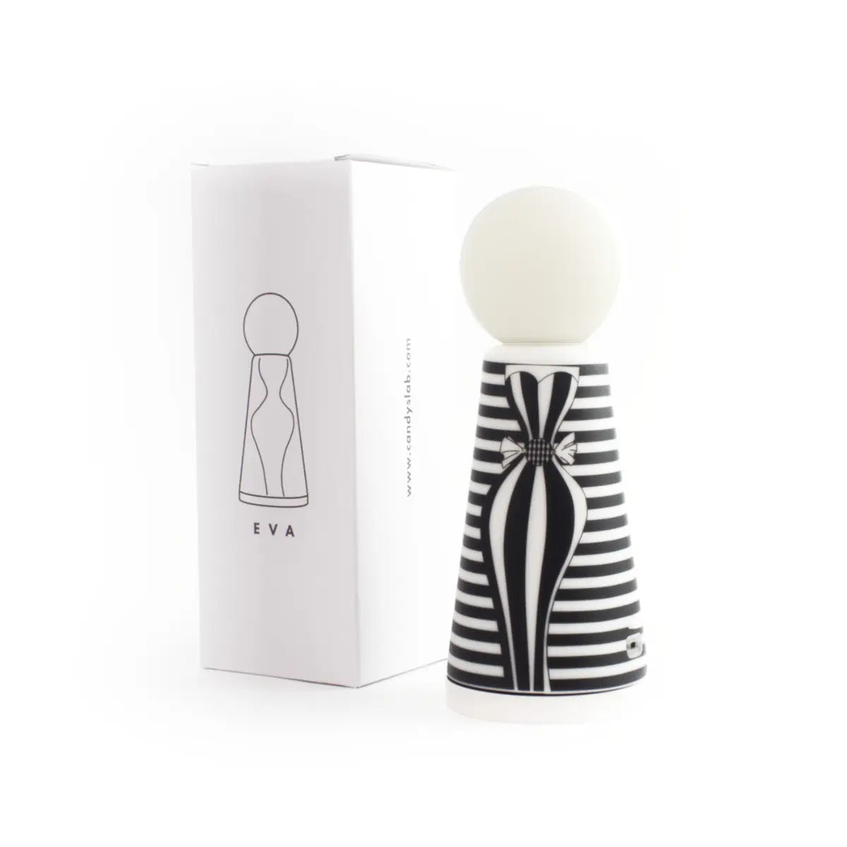 Confezione bianca con scritte e disegni neri. Accanto posizionata lampada da tavolo Eva a righe bianche e nere con disegno di figura femminile. Sfondo bianco 