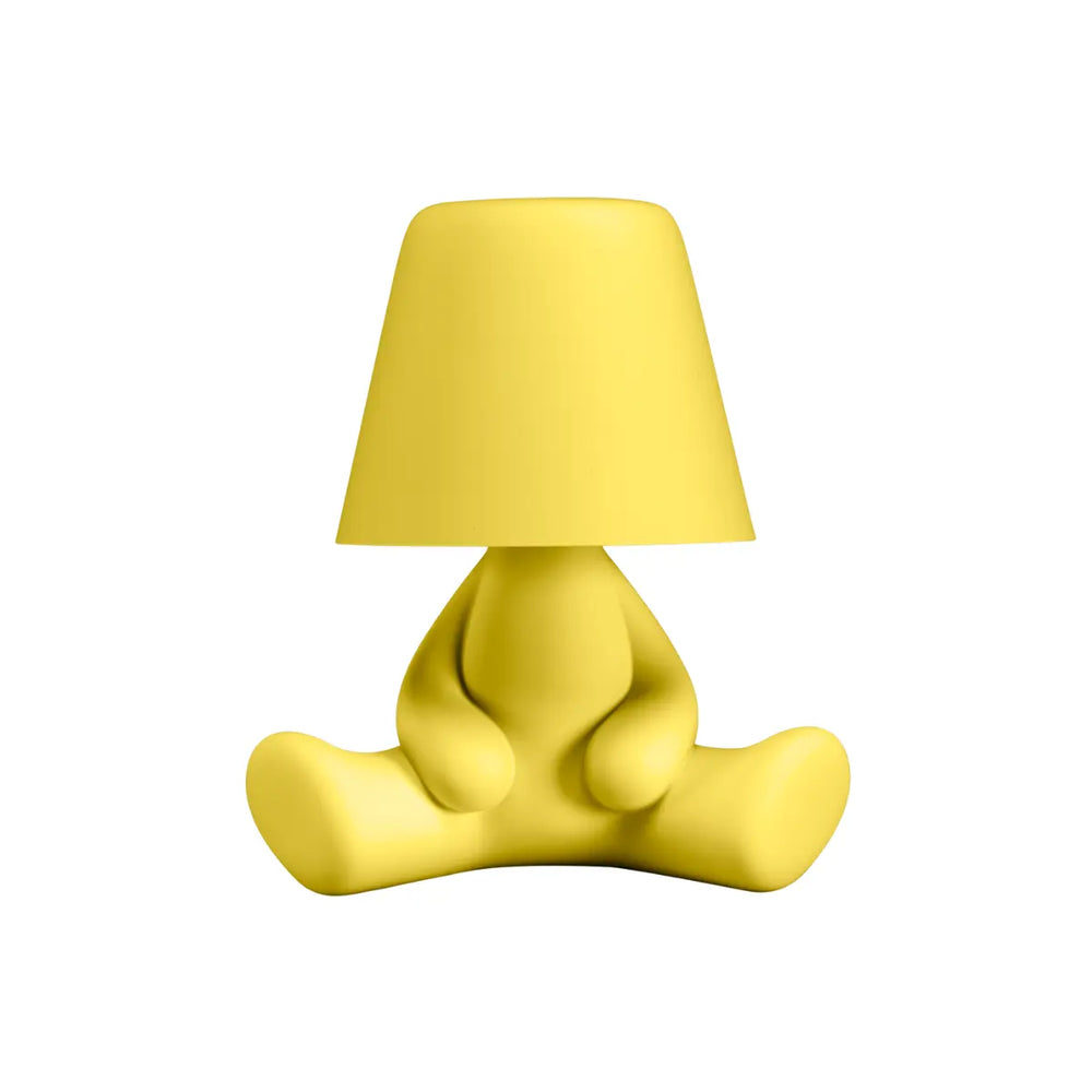 Lampada gialla a forma di personaggio stilizzato seduto a gambe aperte con la testa a paralume