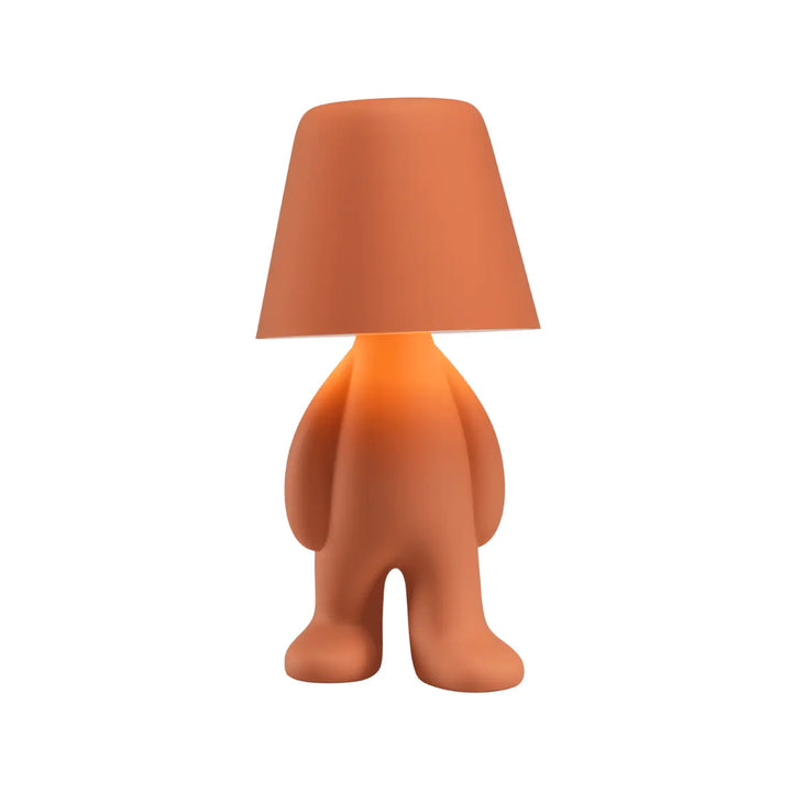 Lampada arancione con struttura a forma di personaggio in piedi con la testa a forma di paralume