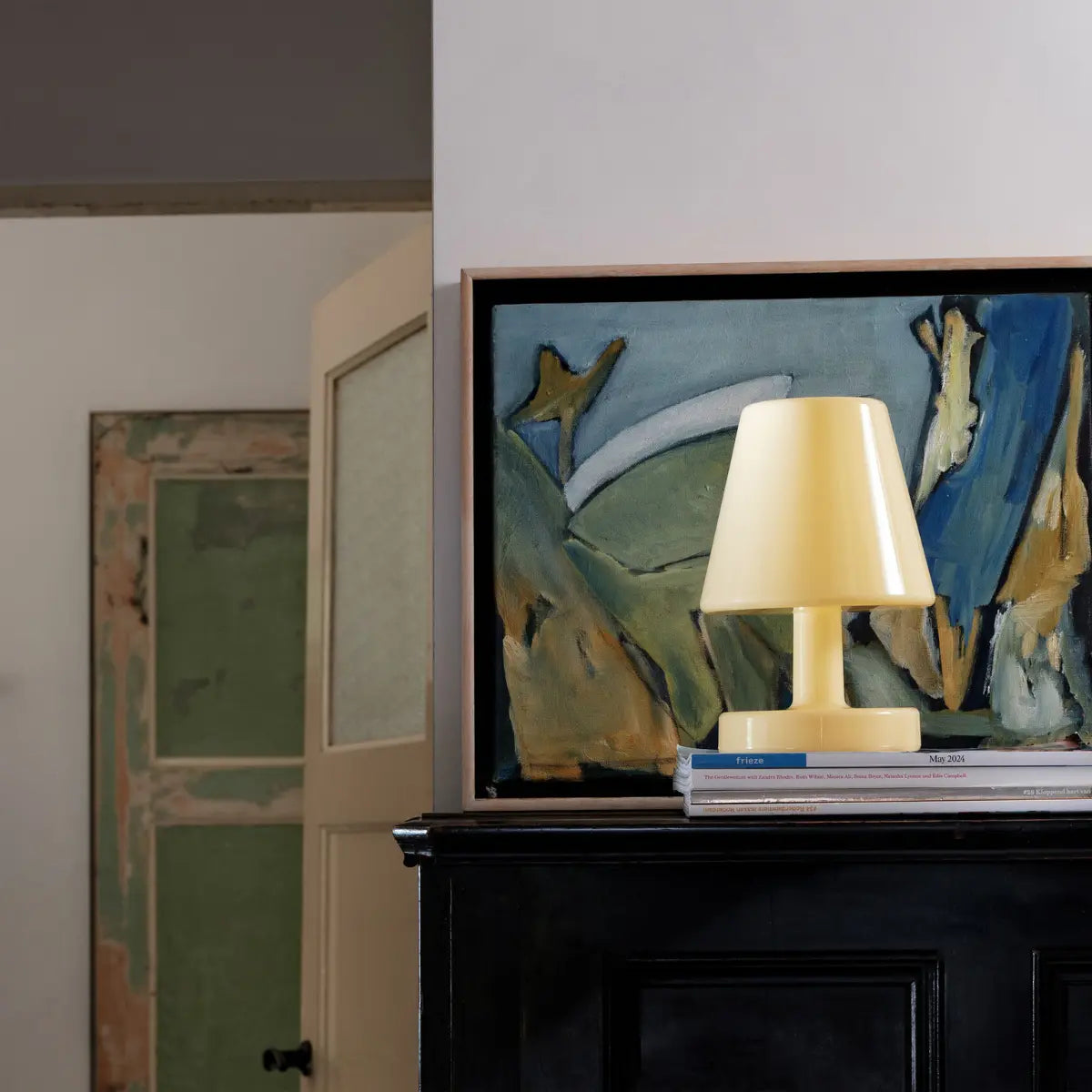 Lampada da tavolo Ambiance di Fatboy lucida color giallo pastello da interno ambientata su un mobile 