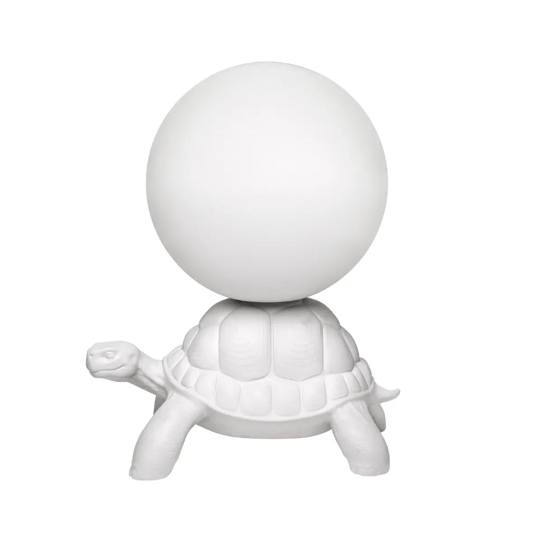 Lato lampada da terra a forma di tartaruga bianca con sfera luminosa sul carapace Qeeboo.
