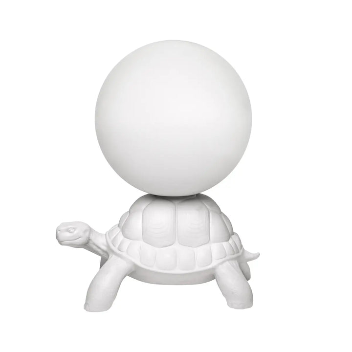 Lato lampada da terra a forma di tartaruga bianca con sfera luminosa sul carapace Qeeboo.
