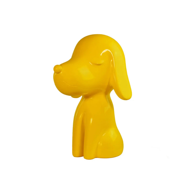 Lato Fronte statua gialla a forma di cane, con occhi naso e bocca. Sfondo bianco